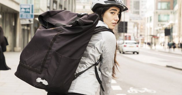 Young female cyclist looks over their shoulder.