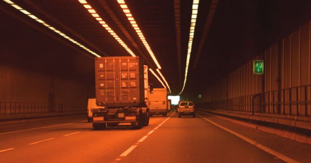 Driving through an orange-lit tunnel from driver's point of view.