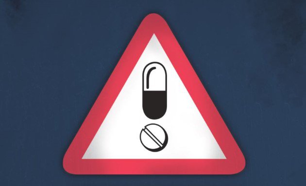 Don't-drug-drive warning sign, pill images inside red triangle.