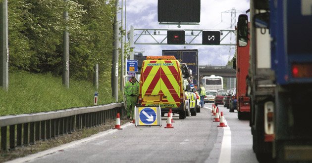 Hard-shoulder highways works with bollards and signage, day.