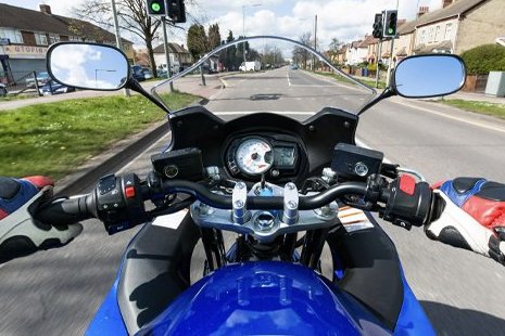 Motorcyclist point of view riding along street, day